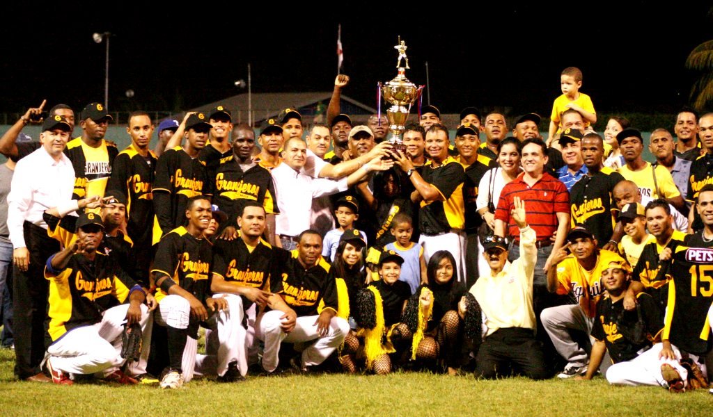 El Lic. Juan Núñez Nepomuceno, secretario General de la Federación Dominicana de Beisbol entrega el trofeo de campeón a los directivos, patrocinados y jugadores de los Campeones nacionales Granjeros de Moca.